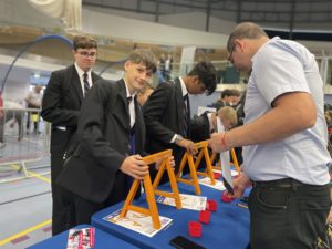 A group of people at a table assembling miniature trestles